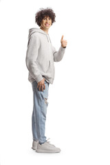 Sticker - Full length portrait of a tall guy with curly hair in a gray hoodie and jeans gesturing thumbs up