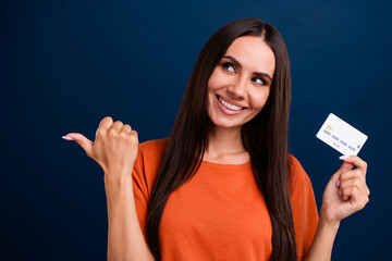 Sticker - Portrait of pretty person wear stylish clothes hold credit card look directing at proposition empty space isolated on dark blue background