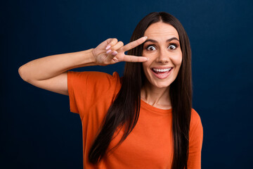 Sticker - Portrait of funky cheeful nice good mood person wear stylish clothes showing v-sign on eye staring isolated on dark blue background