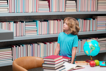 Aufkleber - School boy with stack of books in library. Kid boy from elementary school with book. Little student, smart nerd pupil ready to study. Concept of education and learning.
