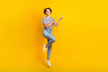 Full Size Photo Of Nice Cheerful Girl Jumping Indicate Fingers Empty Space Proposition Isolated On Yellow Color Background