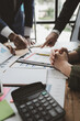 © kamiphotos - Take out financial documents and check them with a calculator, They are planning finances for expenses within the company, Calculate the numbers according to the report sent to the meeting,