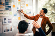 © makibestphoto - Asian middle-age man and mature woman professionals engaged in boardroom meeting. presents data from clipboard to his colleagues, suggesting annual review or planning session.