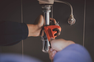 plumber at work in a bathroom, plumbing repair service , fix water plumbing leaks, replace the kitchen sink drain