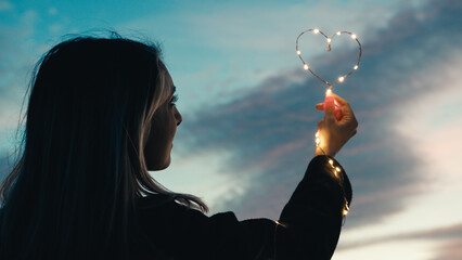 Wall Mural - silhouette of Girl with Heart symbol in the sky