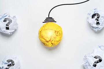 Poster - Glowing Yellow scrap paper ball with drawing wire harness among white scrap paper with question mark for creative thinking idea and problem solving solution concept.