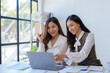 © amnaj - Two young Asian business woman talk, consult, discuss working with new startup project idea presentation analyze plan marketing and investment in the office.