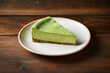 A slice of cheesecake with japanese matcha green tea on the white plate