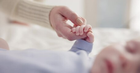 Wall Mural - Parents, family and holding hands with baby on bed for bonding, love and relationship with infant. Adorable, cute and closeup of mom with hand of newborn for support, wellness and protection at home