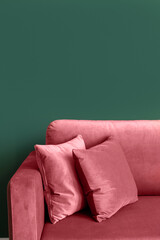 Wall Mural - Vertical shot of red armchair with cushions in modern living room with green wall