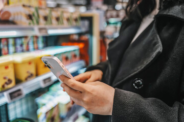 Modern supermarket shopping consumers touch blank smartphones to make purchases