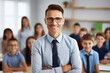 © Anzhela - Smiling male teacher in glasses in class at elementary school looking at camera with learning students on background