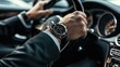 © Oulaphone - Close up of man in black suit wearing watch and keeping hand on the steering wheel while driving a luxury car.