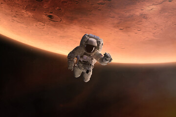 Wall Mural - astronaut is flying in outer space on mars planet background. elements of this image furnished by na