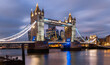 Iconic Tower Bridge in London spanning over river Thames at evening twilight with colorful illumination at christmas time. Landmark, sight and tourist attraction in english metropole from river bank.