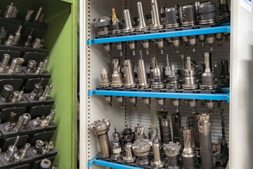 Wall Mural - Mills and cutting tools for working on a CNC machine are arranged. in tool racks.