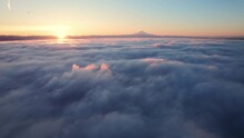 Mt Rainier Aerial Above Clouds With Sunrise On The Horizon
