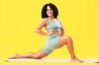 © Pixel-Shot - Sporty adult woman practicing yoga on yellow background