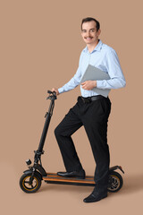 Poster - Portrait of young businessman with clipboard and kick scooter on beige background