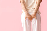Fototapeta  - Young woman with hemorrhoids on pink background, back view