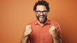 © MP Studio - Joyous man clenching his fists in a triumphant gesture, and shouting in excitement against a plain background.