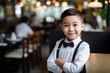 © vasyan_23 - happy asian child boy waiter in restaurant, cafe or bar