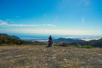 Hombre con moto mirando el paisaje en la costa de Almería, España