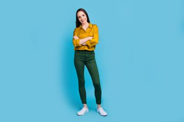 Wall Mural - Full length photo of adorable confident lady wear yellow shirt arms crossed isolated blue color background