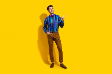 Sticker - Full size photo of pleasant guy dressed striped shirt arm in pocket look directing at sale empty space isolated on yellow color background