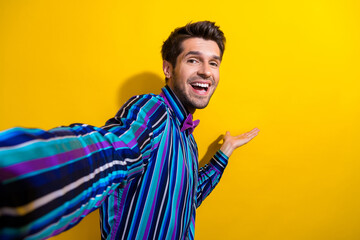 Sticker - Photo of nice man dressed striped shirt bow tie palm presenting product empty space on selfie isolated on vivid yellow color background