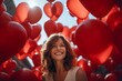 A woman lies on a bed in the middle of red heart-shaped balloons . Valentine's Day