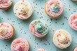 Colorful unicorn cupcakes topped with buttercream icing and sprinkles arranged in a flat lay