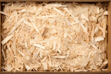 Studio shot of sustainable shredded wood excelsior for filling inside packages, emphasizing natural color and materials.