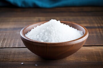 Sea salt in wooden bowl on background