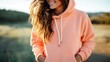 Closeup of a relaxed Peach Fuzz hoodie with oversized drawstrings and a cozy kangaroo pocket.