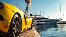 A Sunburst Yellow Supercar Parked At A Luxury Marina, With Yachts And Clear Blue Sky In The Background