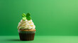 Ein Muffin mit grünen Kleeblatt und grünem Hintergrund in Themenbezug auf den Saint Patrick’s Day, der als Gedenktag für den irischen Bischof heiliger Patrick gilt.