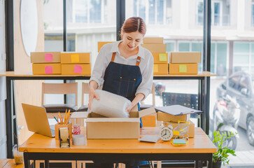 Online small business owners are packing their ordered products into the boxes for their customers based on the concept of online shopping - online shopping.