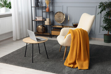 Sticker - Living room interior with comfortable armchair, blanket and side table