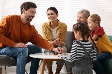 Wall Mural - Family playing checkers at coffee table in room