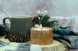 Cup of tea with tea bag, candle, scarf, fir cone and gift boxes on a winter background. Poster for interior. Cozy atmosphere.