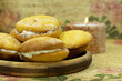 Dessert in the form of cookies with cream and a candle on a vintage background. Poster for interior. Pastries on a wooden saucer and a candle close-up.