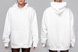 Front and back views of a woman wearing a white, oversized hoodie with blank space, ideal for a mockup, set against gray background