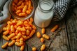 a bowl of cheese puffs next to a bottle of milk
