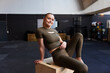 © Flamingo Images - Smiling woman sitting on a box at the gym