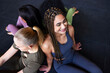 © Flamingo Images - Smiling woman sitting with friends on a gym floor