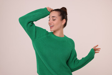 Poster - Beautiful young woman in stylish warm sweater on light grey background