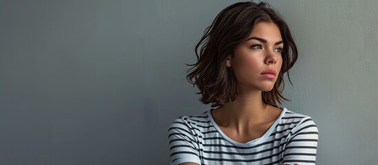 Displeased young beautiful brunette woman wearing striped t shirt over white wall with bad attitude arms crossed looking sideways Negative human emotion facial expression feelings