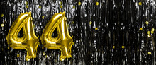Gold Foil Balloon Number Number 44 On A Background Of Black Tinsel Decoration. Birthday Card, Inscription Forty-four. Anniversary Event. Banner.