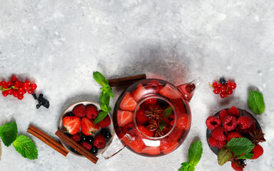 Poster - tea with berries and aromatic herbs in a glass teapot